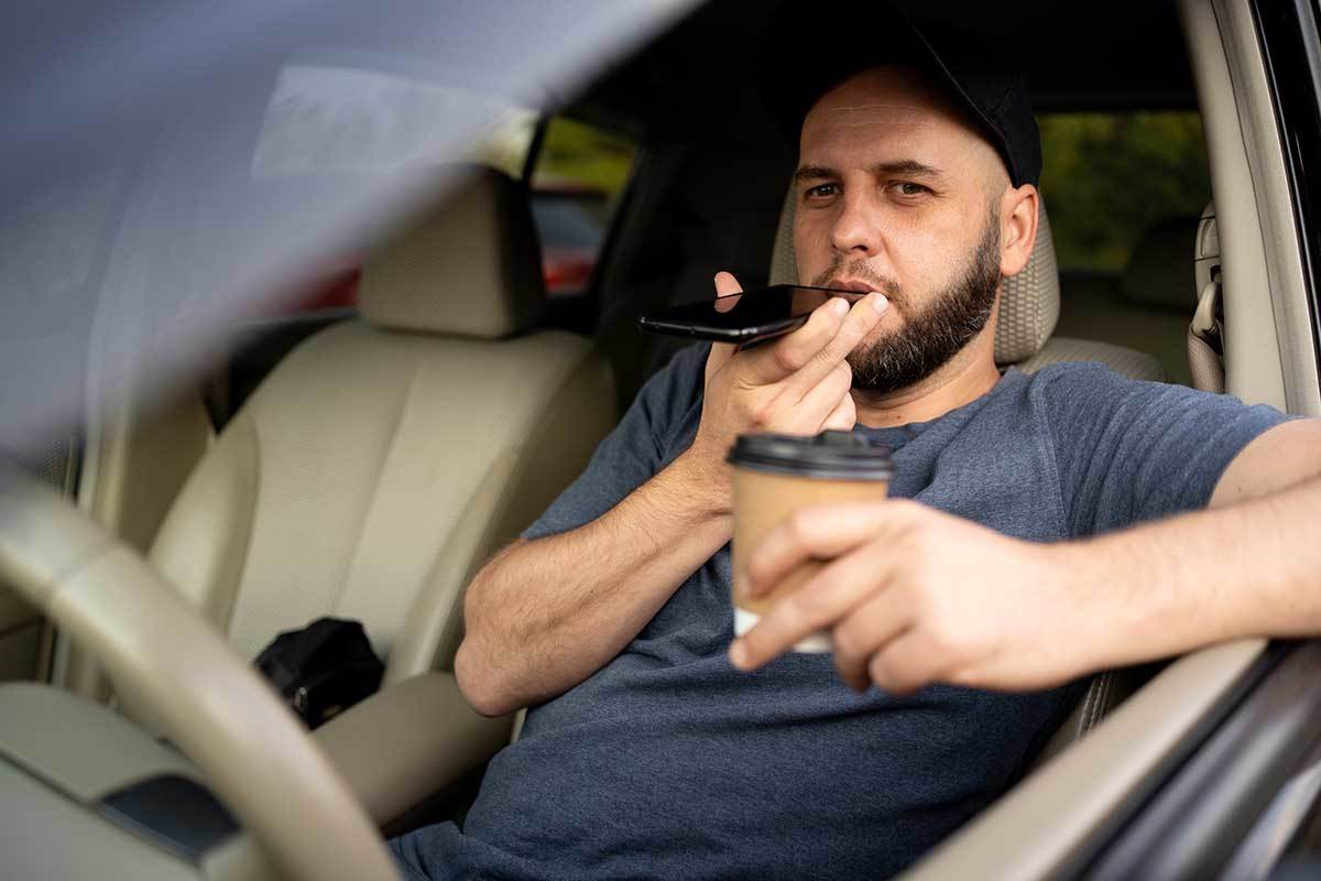 Muškarac u automobilu na spikerfonu Muškarac u automobilu na spikerfonu