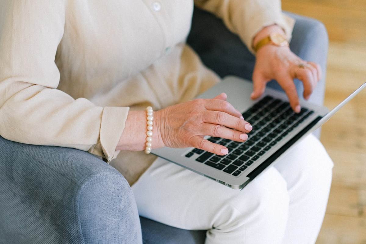  Stara žena kuca na laptopu 