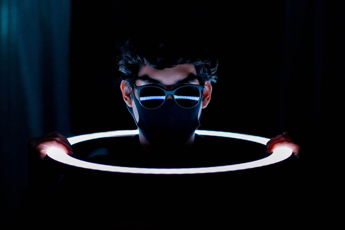  Haker sa maskom i naočarima izvviruje iz svetlog prstena 