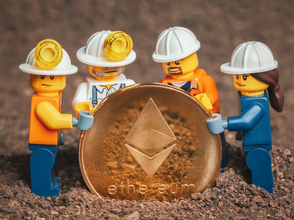Četiri Lego figurice stoje i drže Ethereum novčić   Četiri Lego figurice stoje i drže Ethereum novčić