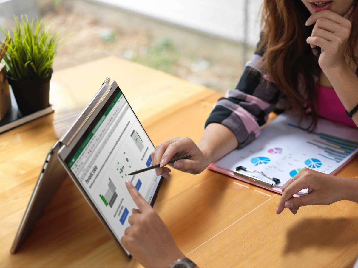 Devojka nešto objašnjava na Lenovo Yoga 9i laptopu na stolu   Devojka nešto objašnjava na Lenovo Yoga 9i laptopu na stolu