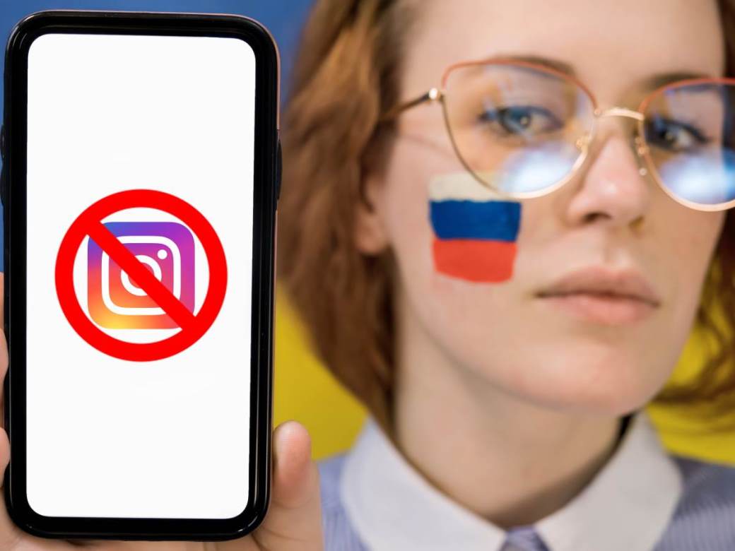 Devojka sa ruskom zastavom na obrazu drži telefon sa precrtanom Instagram ikonicom na ekranu Devojka sa ruskom zastavom na obrazu drži telefon sa precrtanom Instagram ikonicom na ekranu
