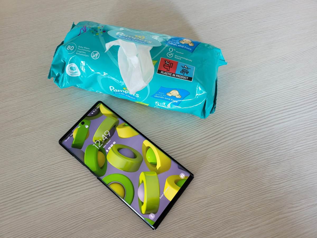 Telefon na stolu pored pakovanja vlažnih maramica Telefon na stolu pored pakovanja vlažnih maramica
