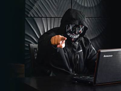Haker sa maskom i kapuljačom za računarom upire prst u vas 